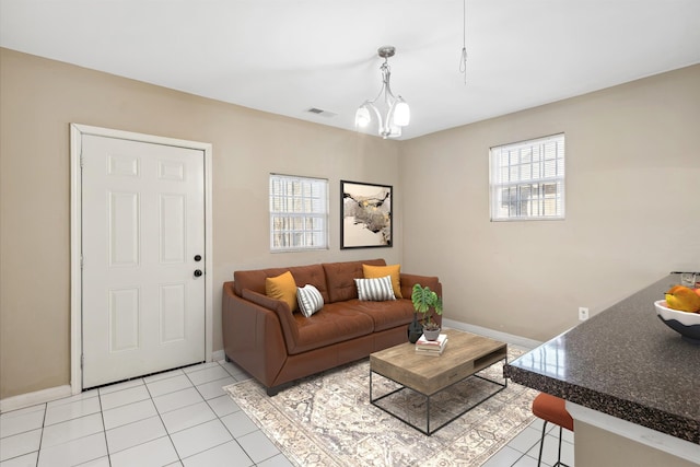 tiled living room featuring a notable chandelier