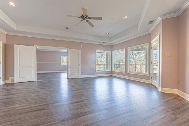 unfurnished room featuring ceiling fan, a raised ceiling, and dark wood-type flooring