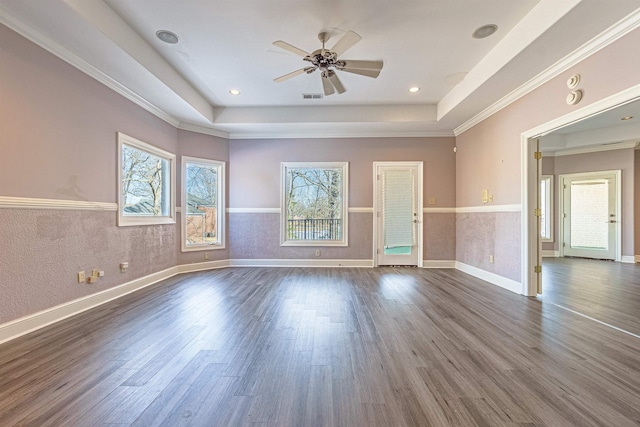 unfurnished room with ceiling fan, dark wood-type flooring, ornamental molding, and a raised ceiling