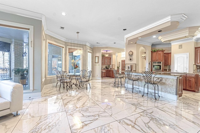 kitchen featuring ornamental molding, plenty of natural light, and a kitchen breakfast bar