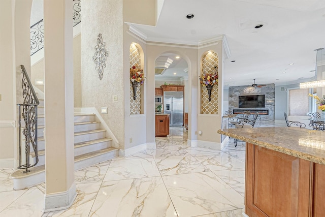 foyer featuring ceiling fan and crown molding