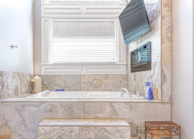 bathroom with a relaxing tiled tub