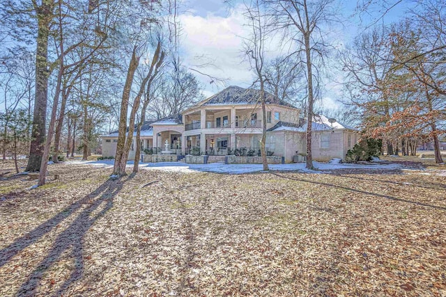 back of house featuring a balcony and a porch