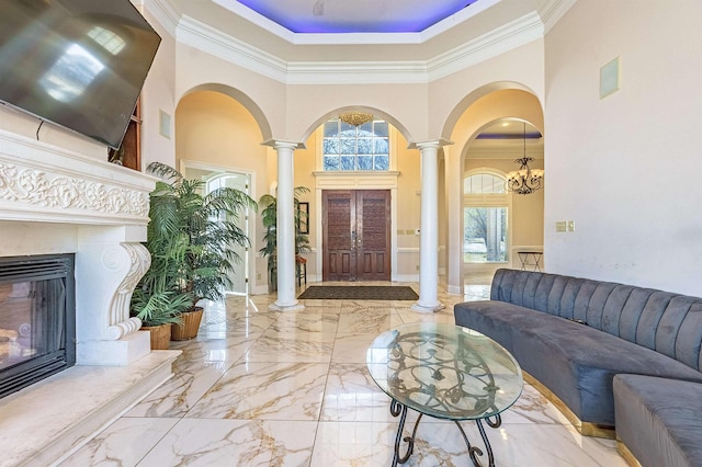 interior space with decorative columns, crown molding, and plenty of natural light