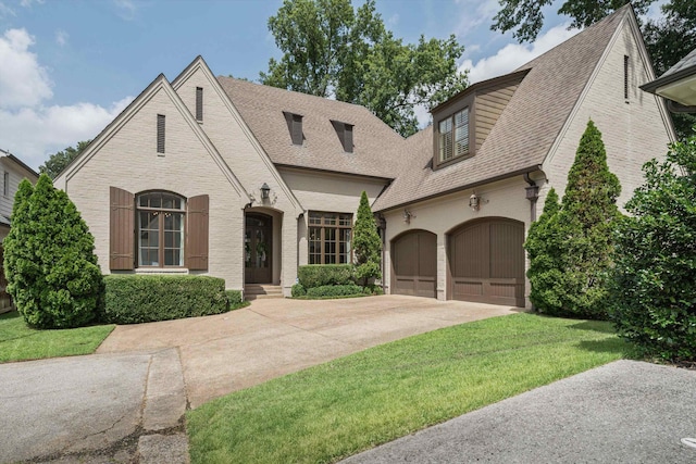 view of front of home with a garage and a front lawn