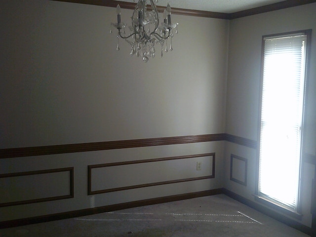 spare room featuring a healthy amount of sunlight and a notable chandelier