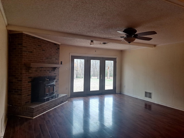 unfurnished living room featuring beamed ceiling, ceiling fan, dark wood-type flooring, and a textured ceiling