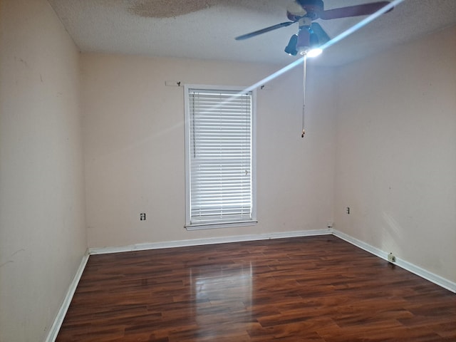 spare room featuring dark hardwood / wood-style flooring, a textured ceiling, and ceiling fan