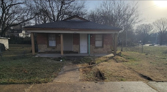 bungalow with a porch and a front lawn