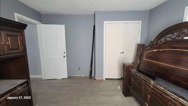 miscellaneous room with a textured ceiling and light wood-type flooring