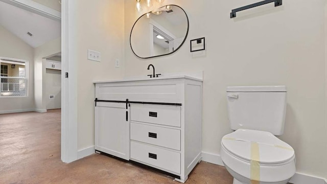 bathroom featuring toilet, lofted ceiling, and vanity