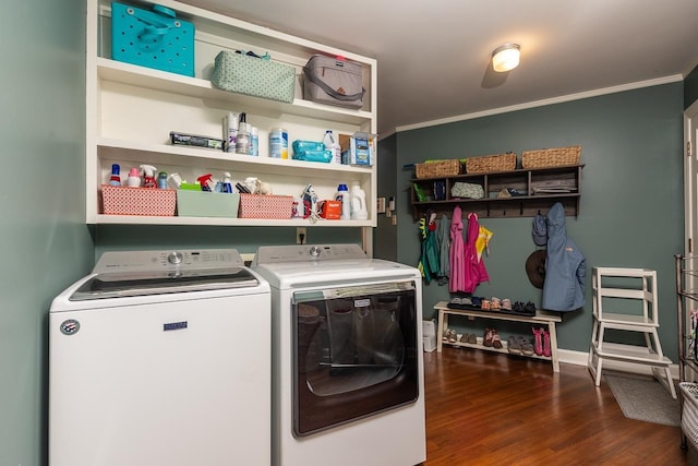 laundry room featuring ornamental molding, washing machine and clothes dryer, and dark hardwood / wood-style flooring