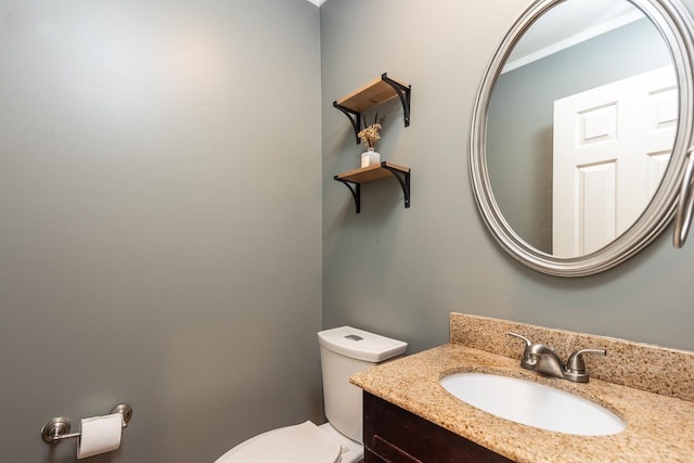 bathroom with crown molding, vanity, and toilet