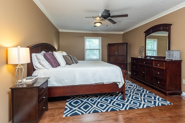 bedroom with ceiling fan, wood-type flooring, multiple windows, and ornamental molding