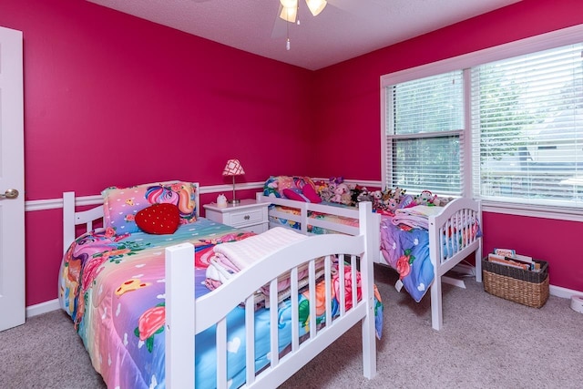 carpeted bedroom featuring a textured ceiling and ceiling fan