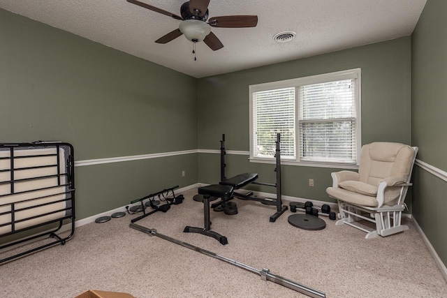 exercise room featuring ceiling fan and a textured ceiling