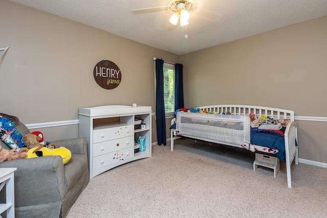 carpeted bedroom featuring ceiling fan and a textured ceiling