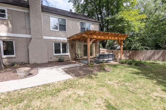 back of house featuring a pergola, a patio area, outdoor lounge area, and a lawn