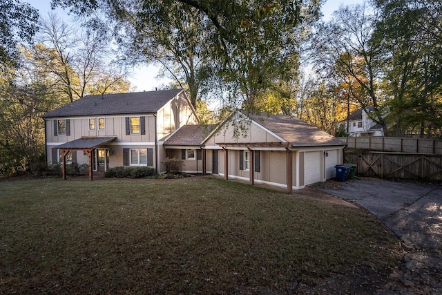 rear view of house featuring a yard and a garage