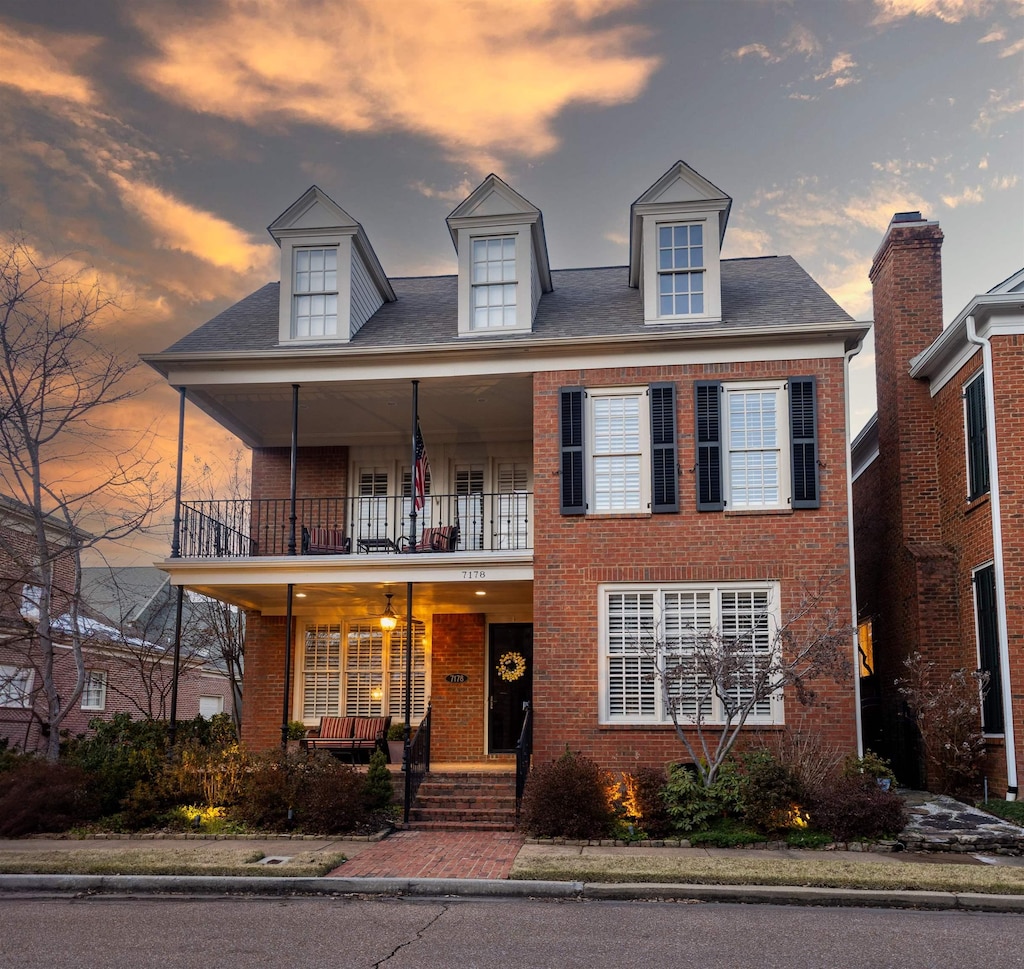 view of front of house with a porch and a balcony