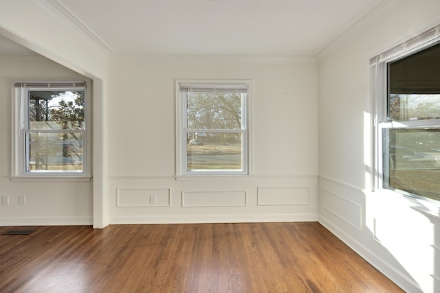 empty room with crown molding and wood-type flooring