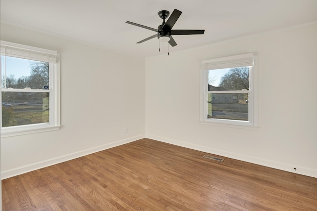 spare room featuring wood-type flooring, ornamental molding, and ceiling fan