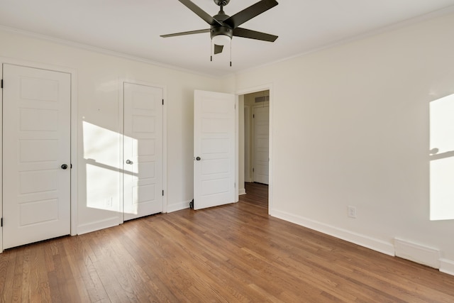 unfurnished bedroom with crown molding, ceiling fan, and wood-type flooring