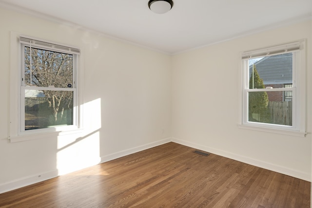 unfurnished room with hardwood / wood-style flooring and crown molding