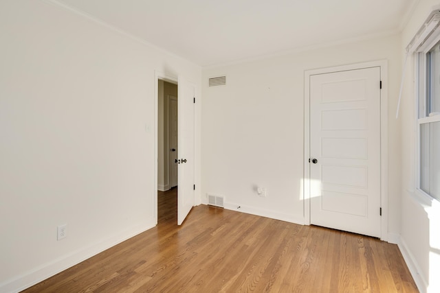 spare room featuring crown molding and wood-type flooring