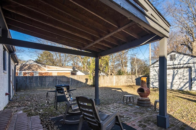 view of patio featuring an outdoor brick fireplace and an outdoor structure