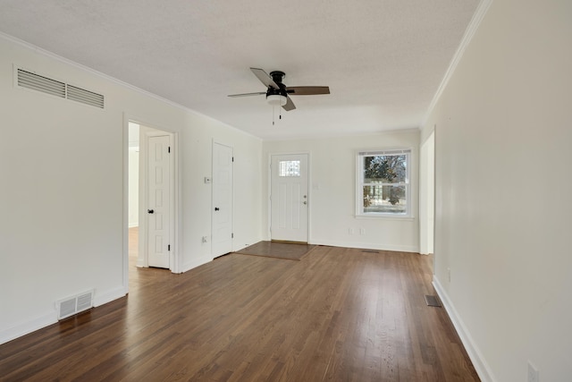 interior space featuring ceiling fan, ornamental molding, dark hardwood / wood-style flooring, and a textured ceiling