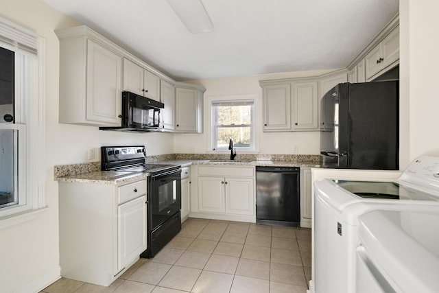 kitchen featuring separate washer and dryer, sink, light tile patterned floors, and black appliances