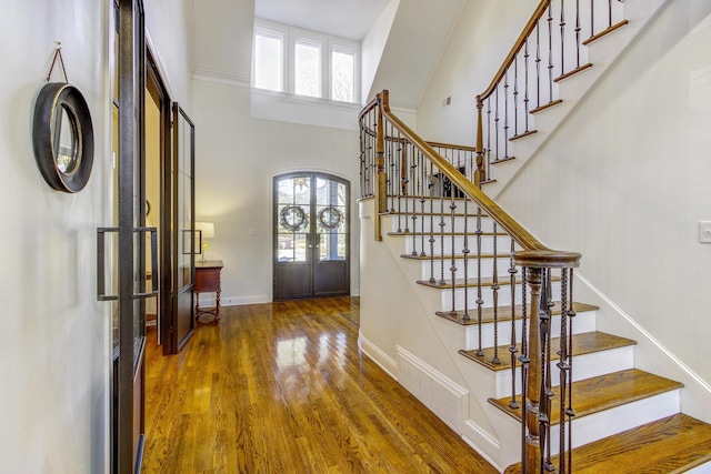 entryway with dark wood-type flooring, french doors, and a high ceiling