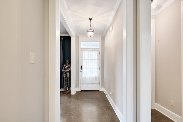 hall featuring ornamental molding and dark tile patterned floors