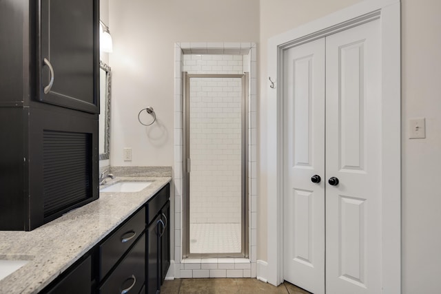 bathroom featuring tile patterned flooring, vanity, and a shower with shower door