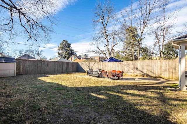 view of yard featuring a shed and a patio area