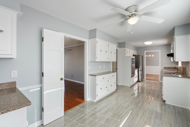 kitchen with sink, ceiling fan, appliances with stainless steel finishes, light hardwood / wood-style floors, and white cabinets