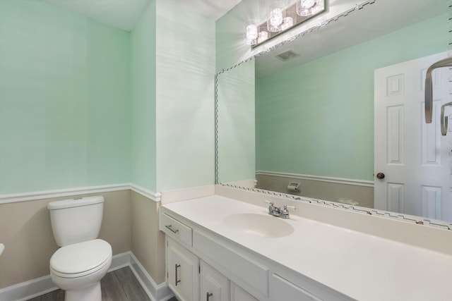 bathroom with vanity, hardwood / wood-style floors, and toilet