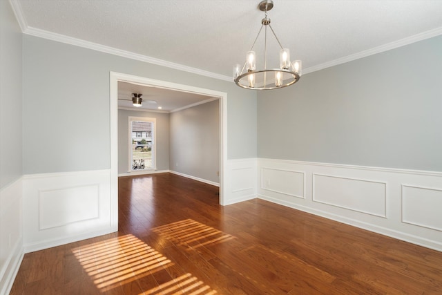 spare room featuring crown molding, dark wood-type flooring, and a notable chandelier