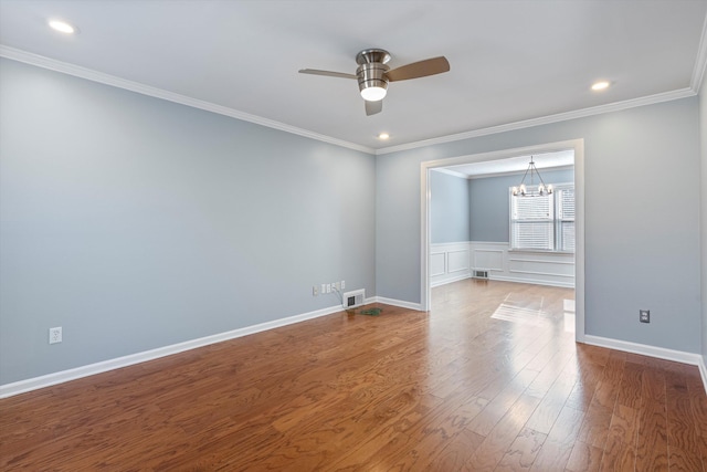 spare room with ornamental molding, ceiling fan with notable chandelier, and wood-type flooring