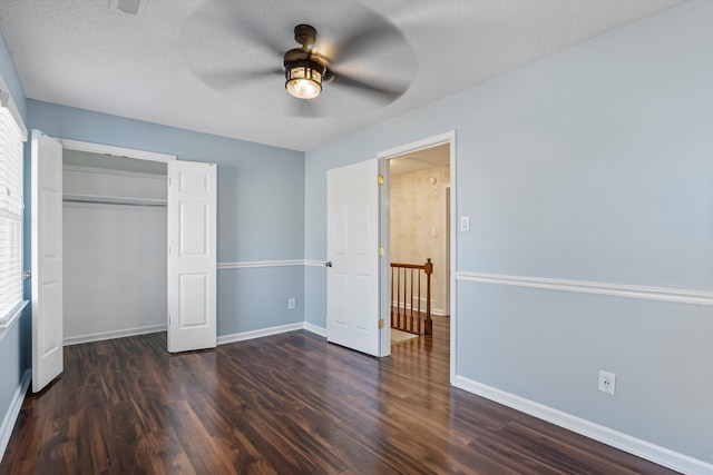 unfurnished bedroom with dark hardwood / wood-style flooring, a textured ceiling, a closet, and ceiling fan