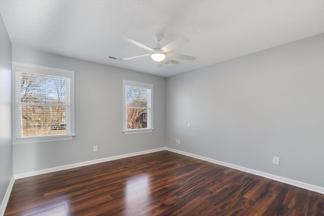 empty room with a textured ceiling, dark hardwood / wood-style floors, and ceiling fan