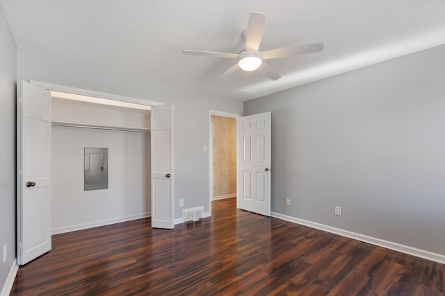 unfurnished bedroom with ceiling fan, dark hardwood / wood-style flooring, electric panel, and a closet