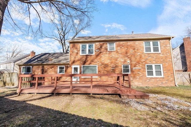 rear view of house featuring a lawn and a deck