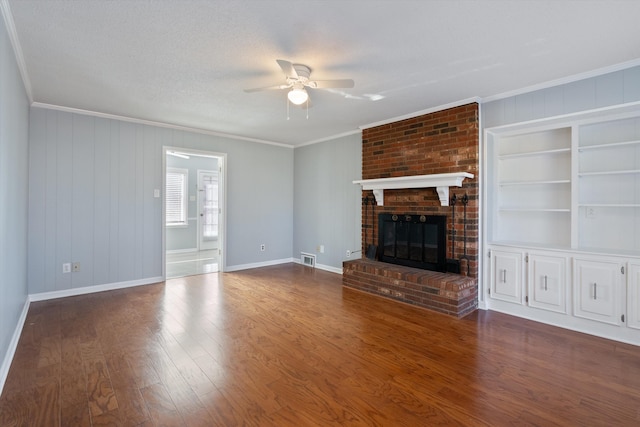 unfurnished living room featuring crown molding, a textured ceiling, dark hardwood / wood-style floors, ceiling fan, and a fireplace