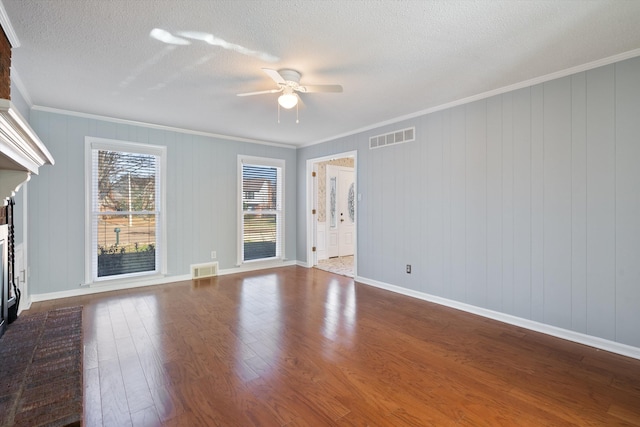 unfurnished living room featuring crown molding, wood-type flooring, a textured ceiling, ceiling fan, and a fireplace