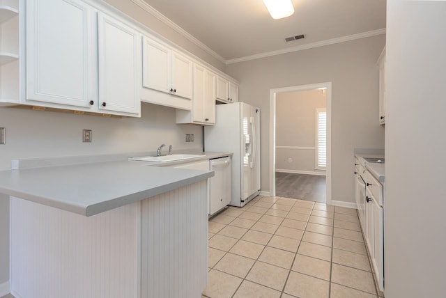 kitchen featuring sink, light tile patterned floors, ornamental molding, white appliances, and white cabinets