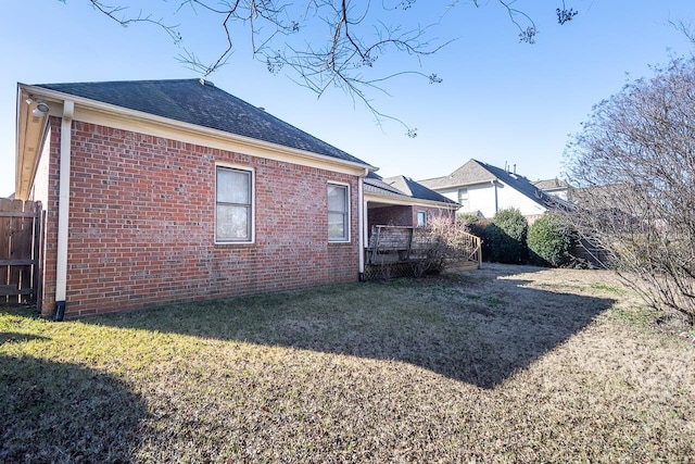 view of home's exterior featuring a wooden deck and a yard