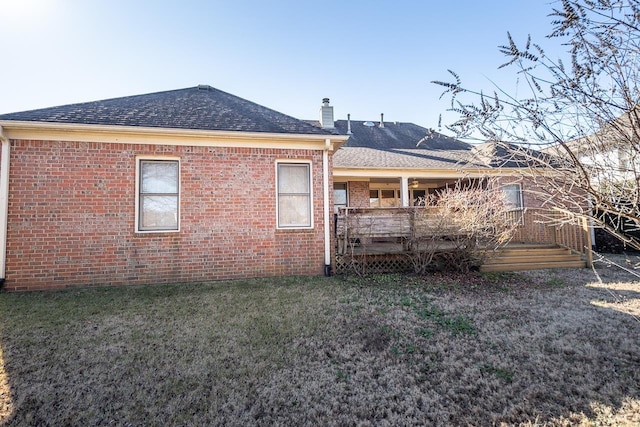 rear view of property featuring a wooden deck and a yard