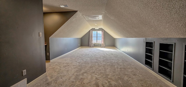 bonus room featuring vaulted ceiling, carpet floors, built in features, and a textured ceiling